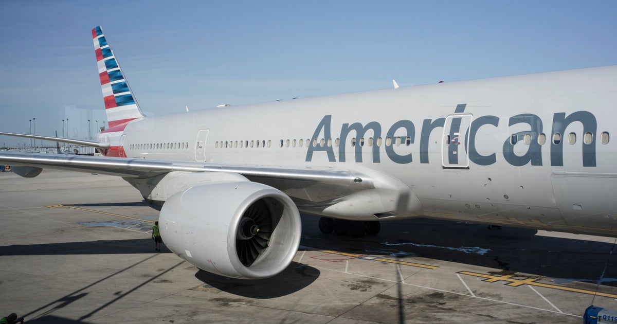 A Delta Air Lines jet and an American Airlines jet parked at airport gates as fuel trucks refuel aircraft