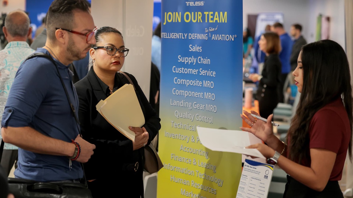 Job seekers speak with a recruiter at an aviation industry career fair. Source: CNBC