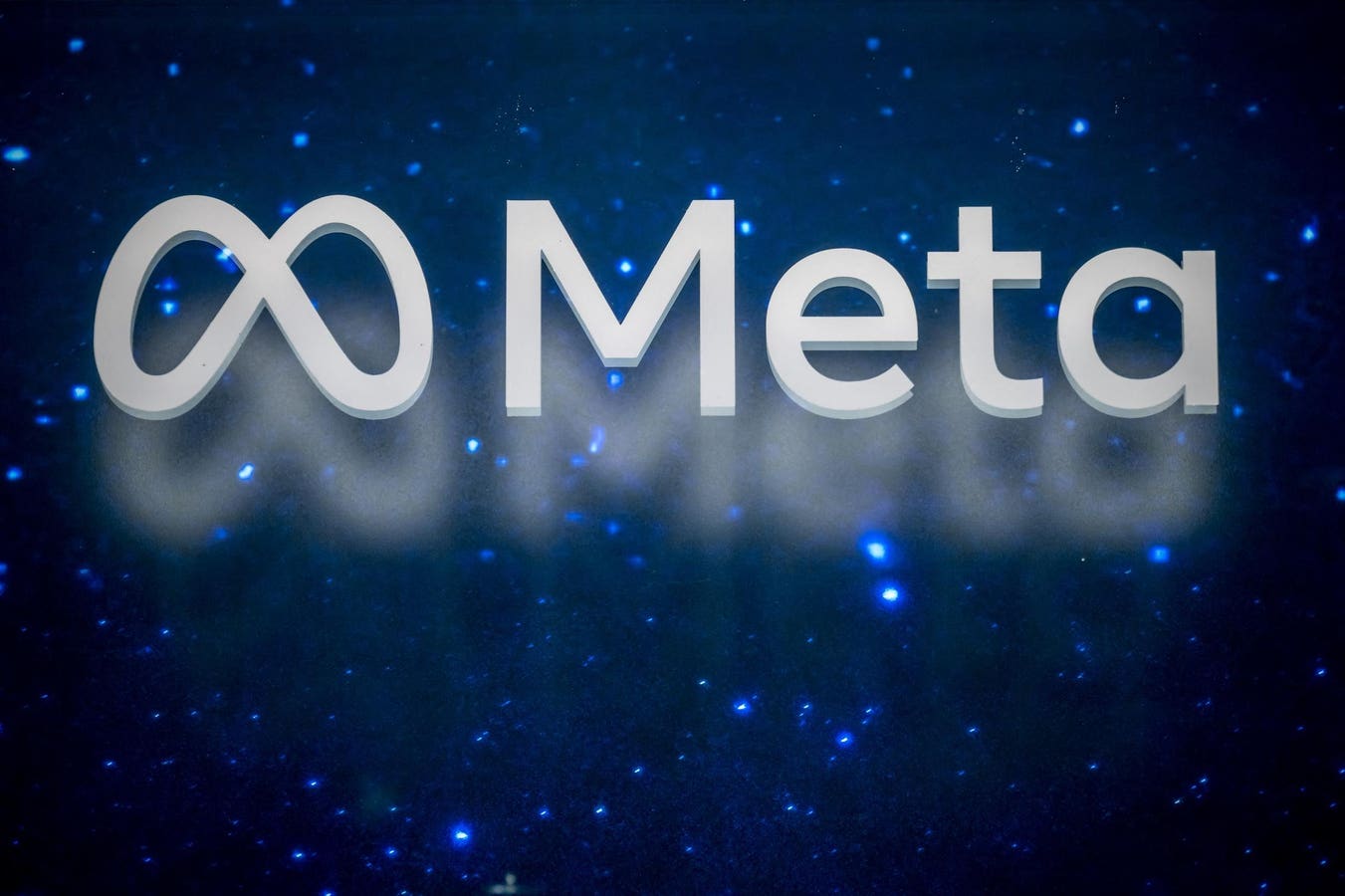 Meta Platforms logo displayed on a screen alongside rows of AI data center servers representing the company's cloud computing ambitions