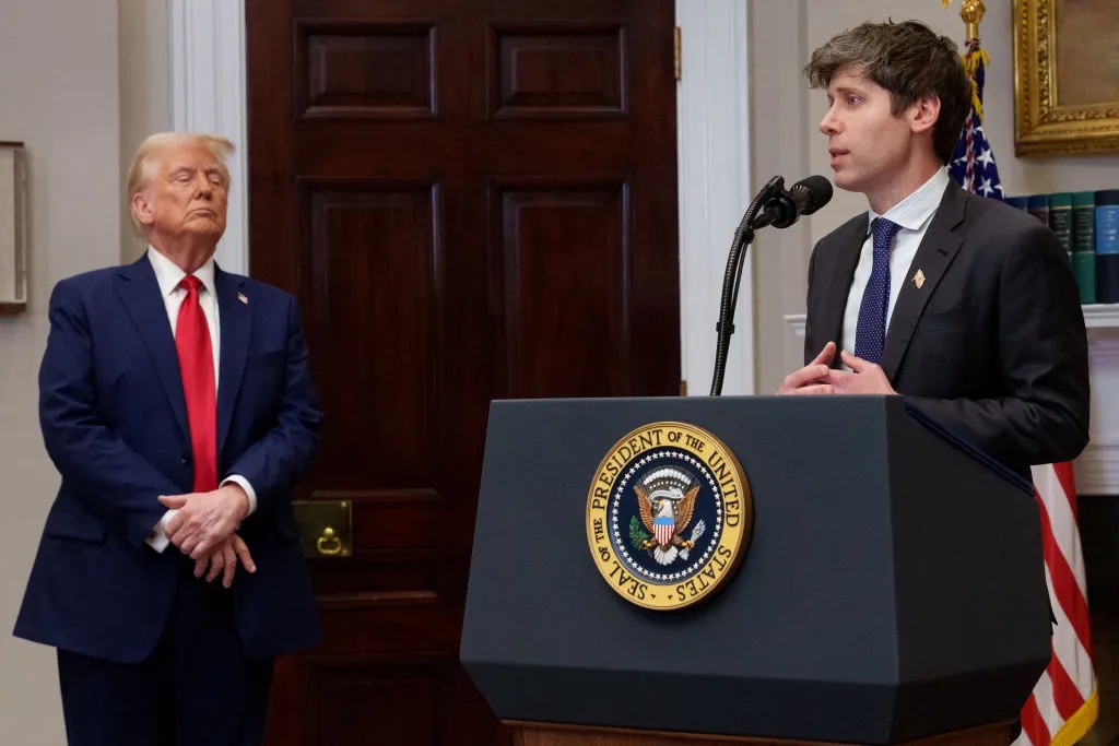 Sam Altman speaks at a White House podium as President Donald Trump looks on. Source: TechCrunch