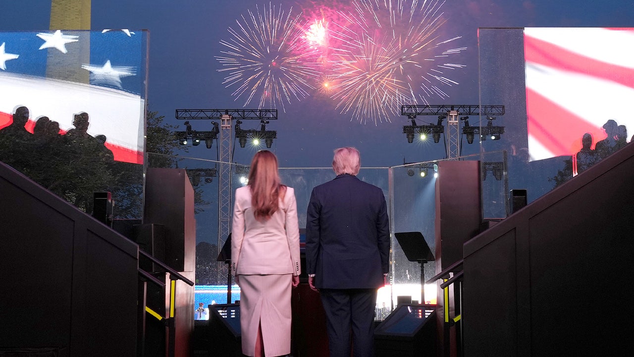 President Trump speaking at Mount Rushmore National Memorial at night as fireworks burst above the four carved presidential faces