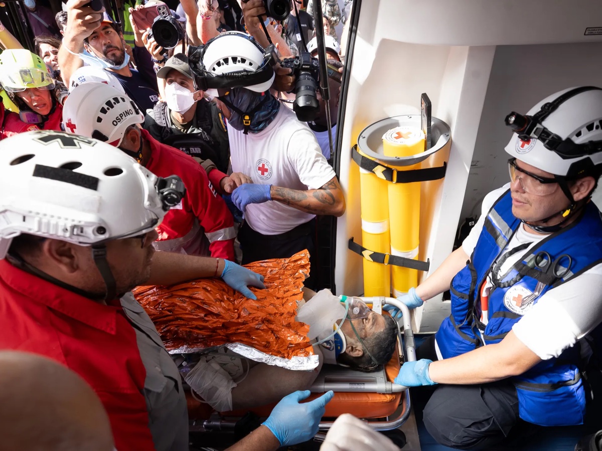 Red Cross workers carry a survivor to an ambulance after the Venezuela earthquake. Source: Al Jazeera